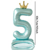 A large, light blue foil number balloon shaped like the numeral 5 with a gold crown on top.