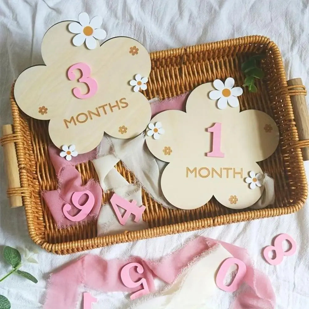 Wooden monthly milestone cards showing 3 months and 1 month with pink ribbon accents
