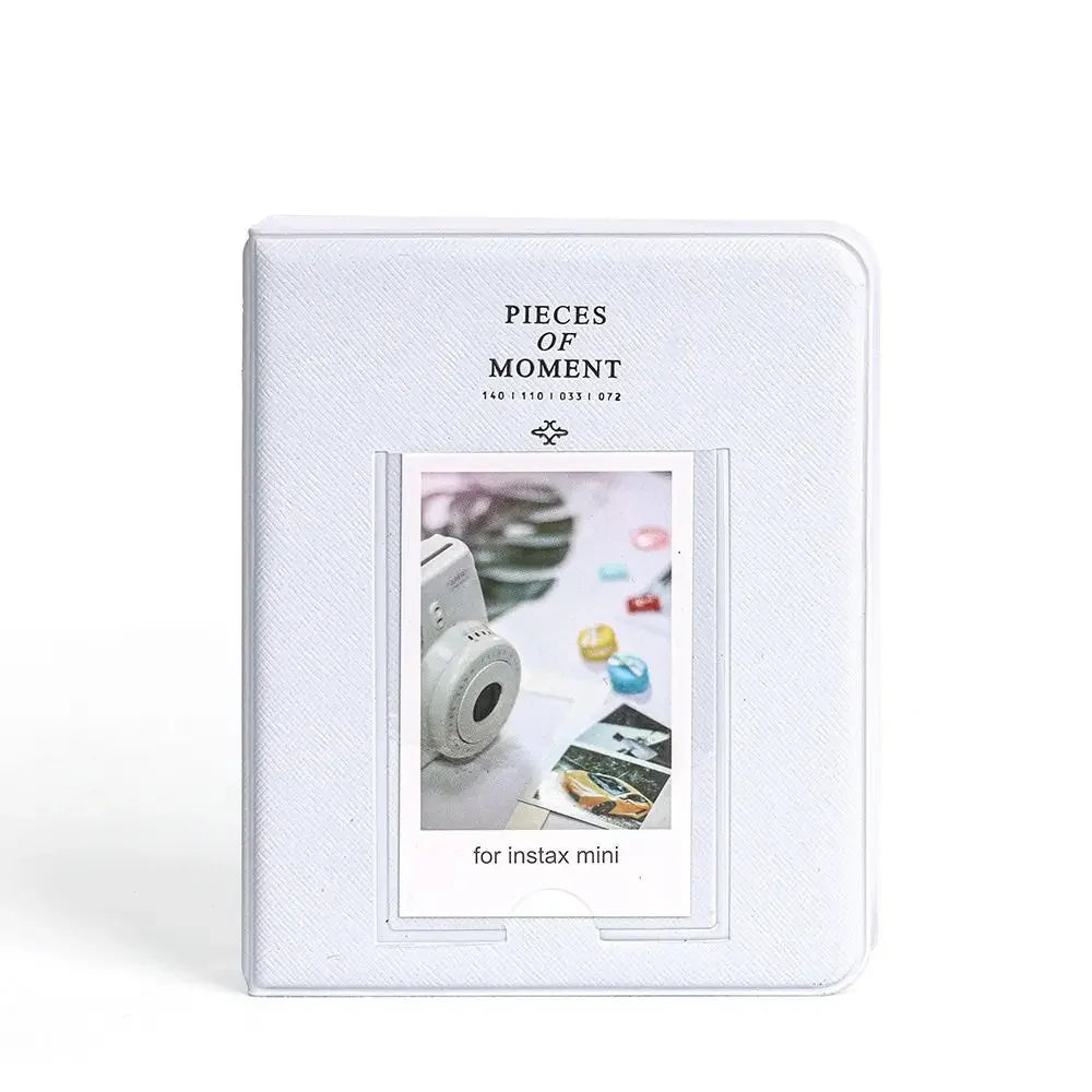 A white sleeve holding a piece of paper with the text Pieces of Moment and an inset photo for Instax mini cameras.