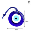 A dark blue glass evil eye amulet pendant with a white center and a thin purple cord.