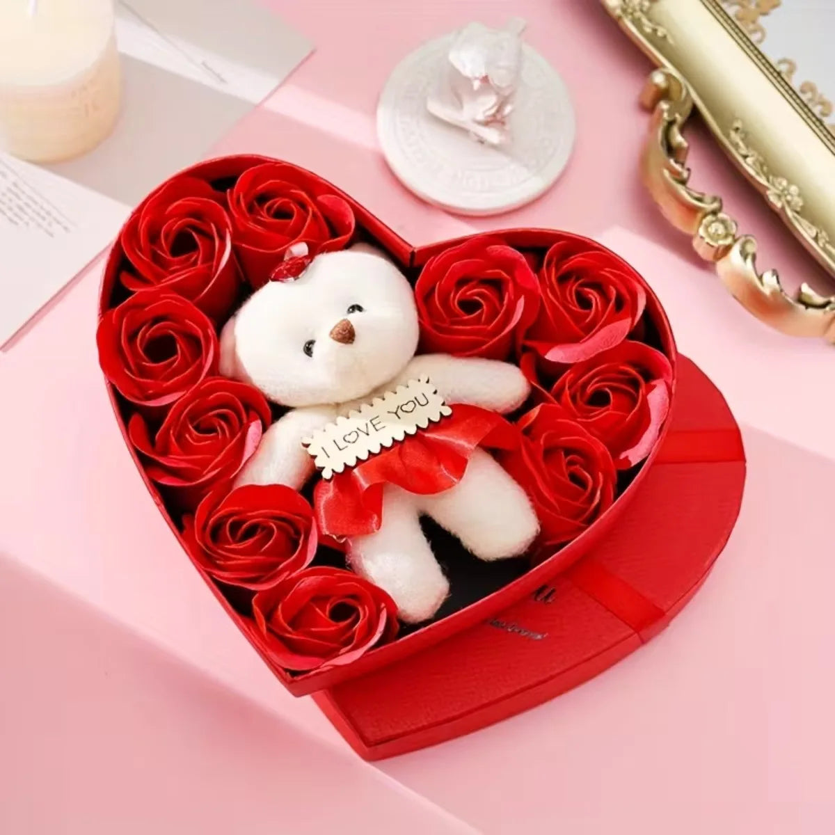 A red gift box filled with artificial red roses and a white plush bear wearing a red ribbon.