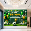 A green soccer field backdrop for a birthday party featuring a goal, trophies, crowns, and various soccer balls.