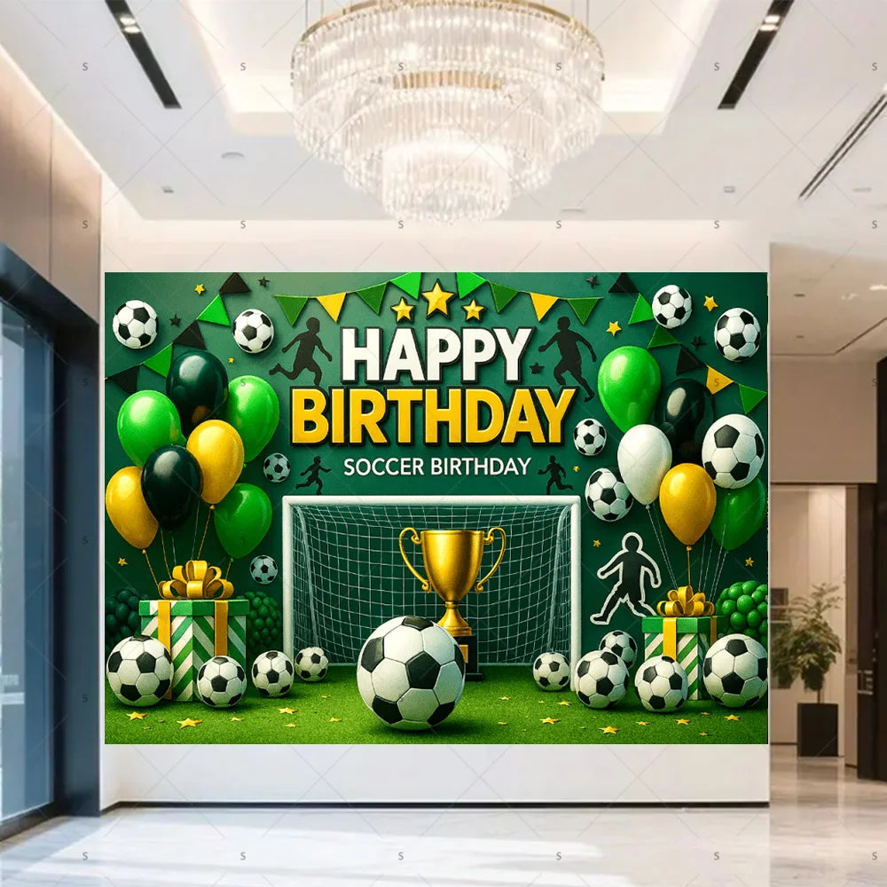 A green soccer field backdrop for a birthday party featuring a goal, trophies, crowns, and various soccer balls.