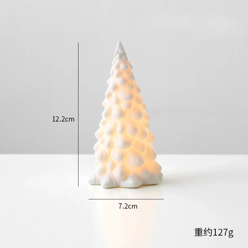 A white ceramic glow-in-the-dark mini Christmas tree decor shaped like a conical pine tree.