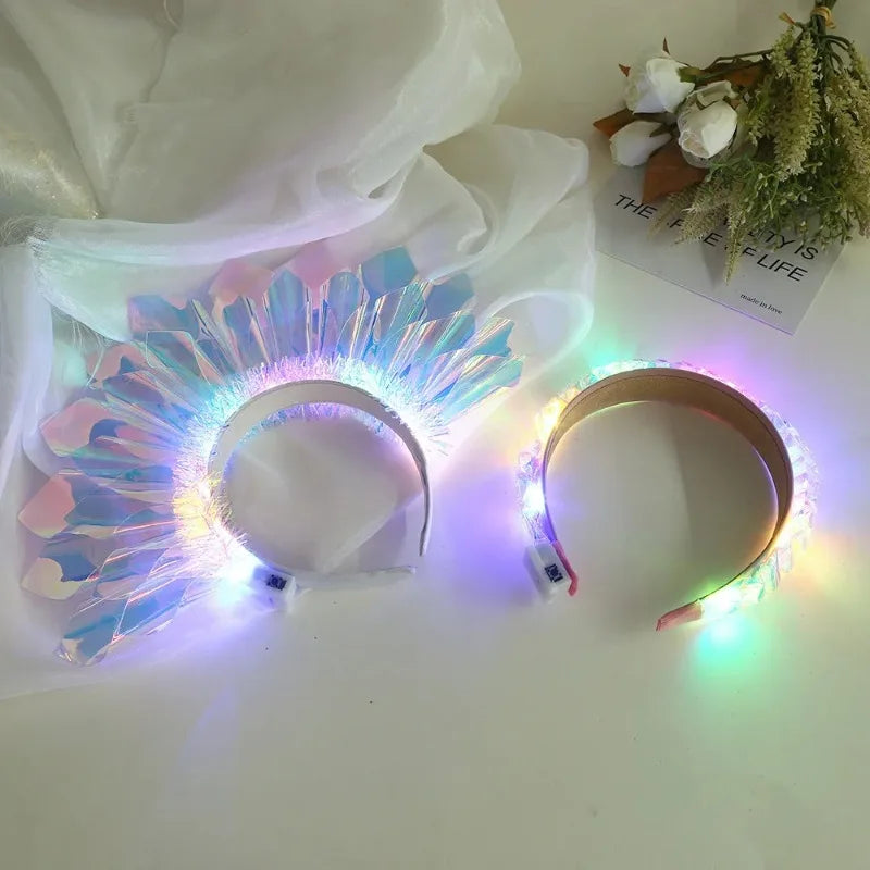 A glowing LED headband with a flower-like design is displayed on a white surface.