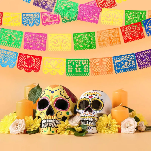 A colorful papel picado bunting banner featuring intricate cut-out designs in pink, green, yellow, and red hues.