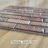 A rectangular pattern of brown and gray 3D brick wall stickers placed on a light wooden surface.