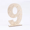 A light wood display stand shaped like the number 9, featuring small wooden sticks for decoration.