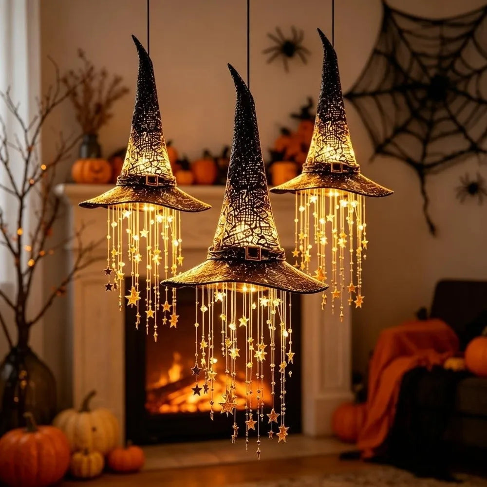 A glowing witch hat hanging chime with star tassels suspended above a fireplace.
