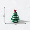 A small, green resin Christmas tree charm with a red heart topper, shown against a white background.
