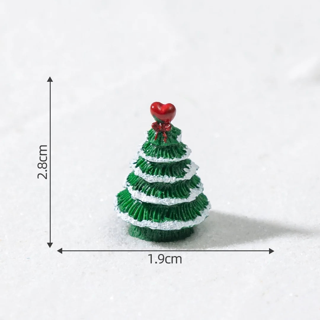 A small, green resin Christmas tree charm with a red heart topper, shown against a white background.