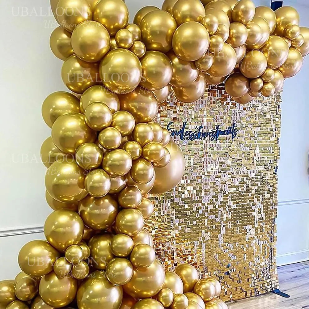 A large balloon garland made of metallic chrome gold balloons against a gold glitter background.