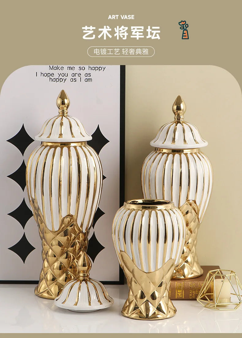 A set of golden and white striped ceramic art vases displayed on a light surface.