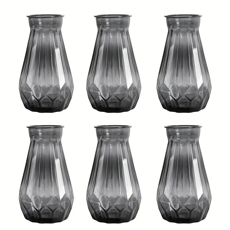 A set of four faceted diamond crystal clear plastic vases for table decor.