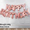 A string of 13 foil letter balloons spelling out Happy Birthday across a white door.