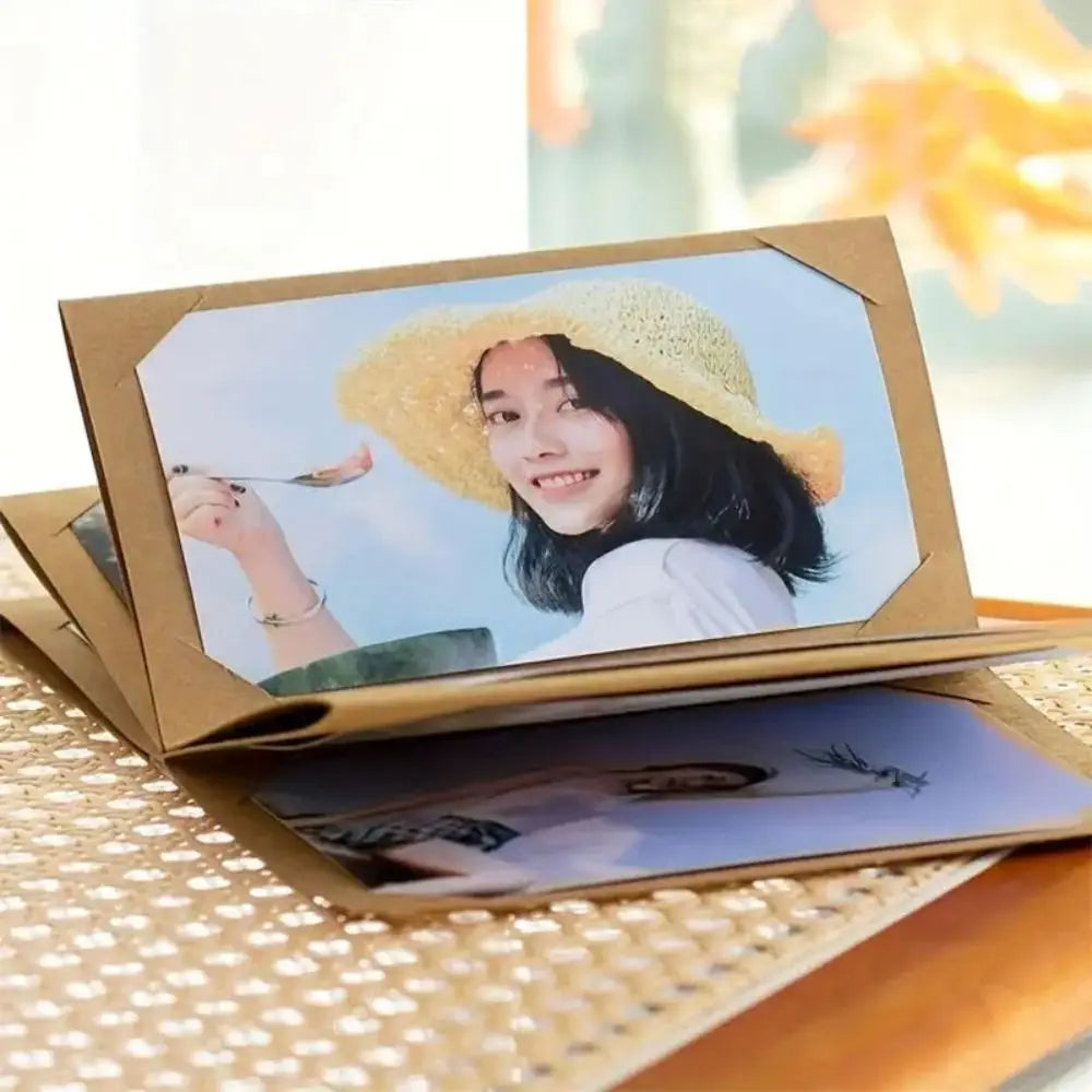 A photo album with a gold frame displaying a portrait of a smiling young girl wearing a yellow hat.