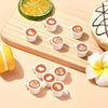 A set of ten miniature white coffee mugs filled with latte art on a wooden board.