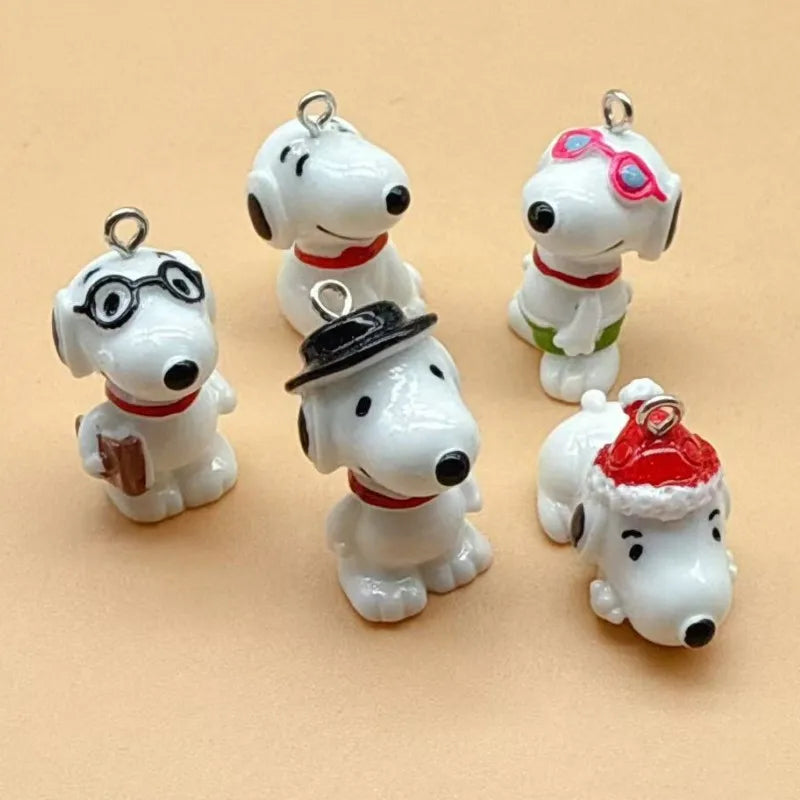 Three white dog pendants with different accessories like glasses a hat and a Santa hat