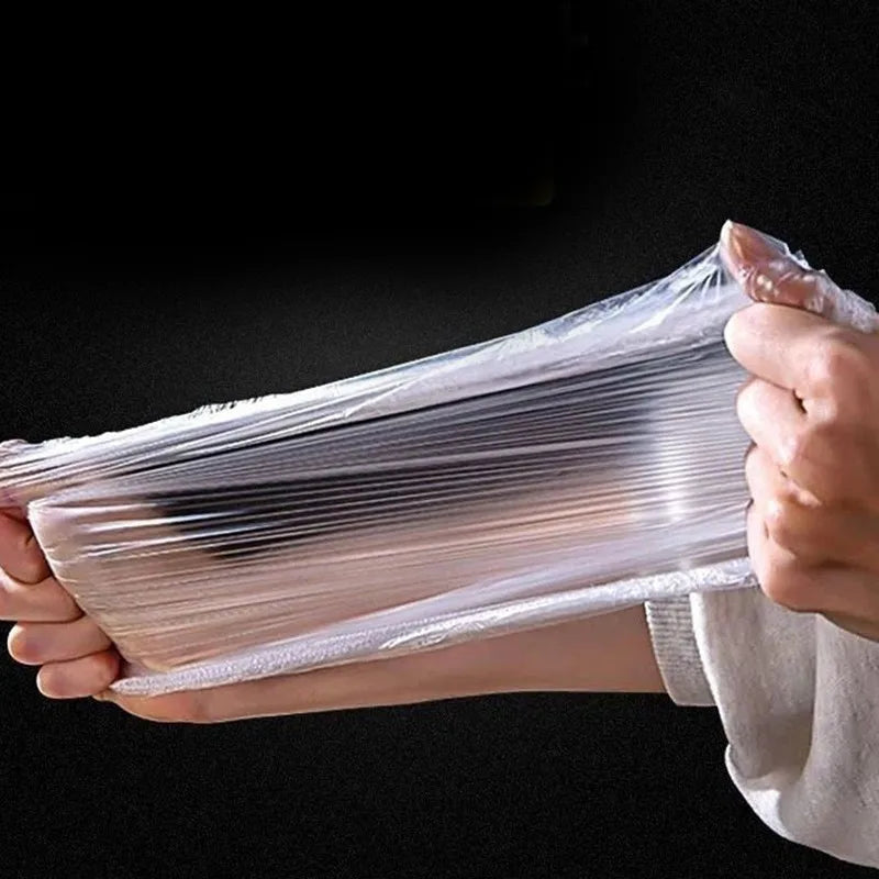 Hands holding a clear plastic wrap containing disposable elastic bowl covers for food.