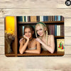 Deux jeunes femmes posant dans une bibliothèque en bois avec des livres et des fleurs.