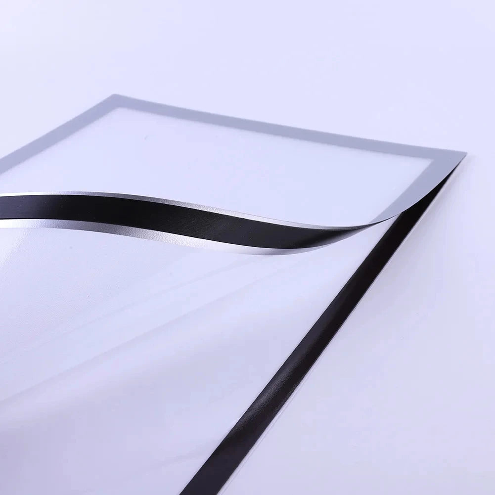 A close-up view of a magnetic poster display frame with a silver and black curved edge.