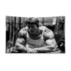 A black and white photo of a muscular man posing in a bodybuilding gym setting.