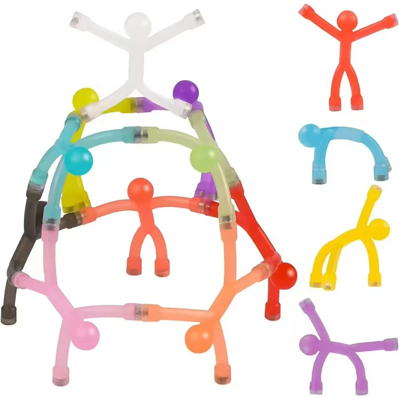 A collection of colorful plastic fridge magnets shaped like human figures in various poses and colors.