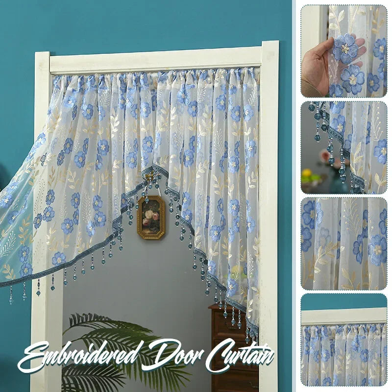 Embroidered sheer lace door curtain featuring blue floral patterns and silver tassels hanging in a white frame.