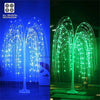 A weeping willow tree light display with bright blue and green LED lights illuminating a dark outdoor scene.
