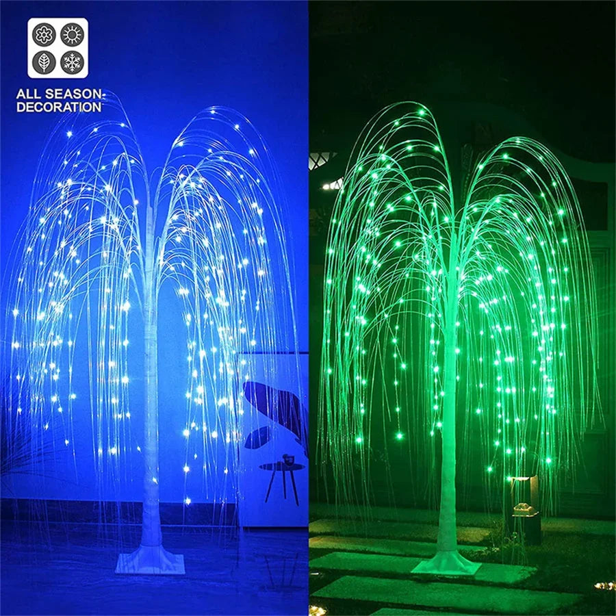 A weeping willow tree light display with bright blue and green LED lights illuminating a dark outdoor scene.
