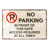 A rectangular metal sign with a red circle and slash over the letter P indicating no parking in front of a gate.