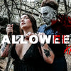 A woman holding a bloody horror mask resembling Michael Myers in a dark, wooded setting.