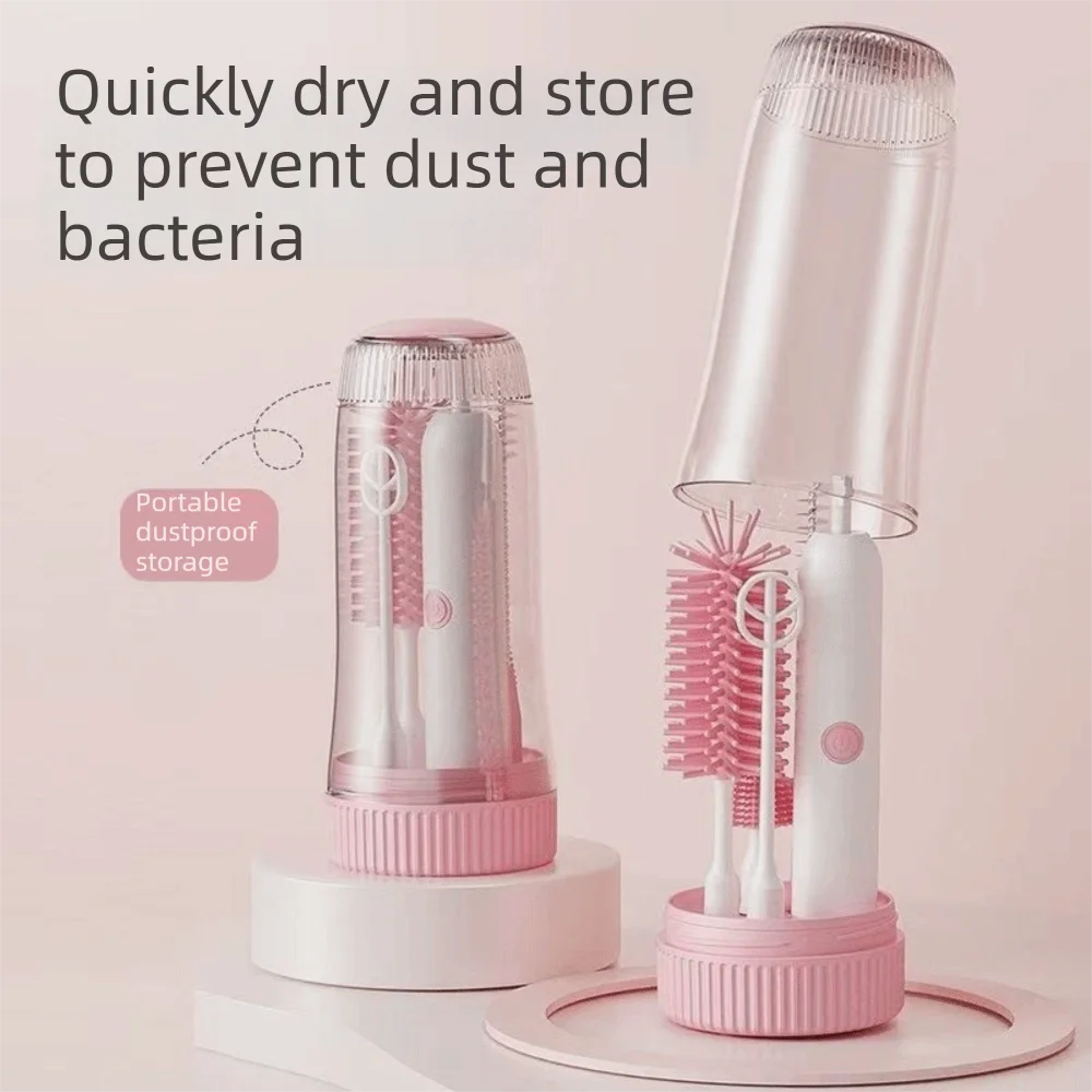 A clear plastic storage case holds a white electric baby bottle cleaning brush with multiple bristles.