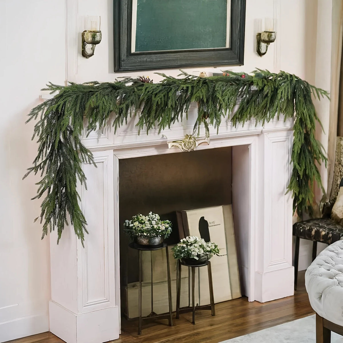 An artificial Norfolk pine garland with warm white lights draped across a white fireplace mantel.
