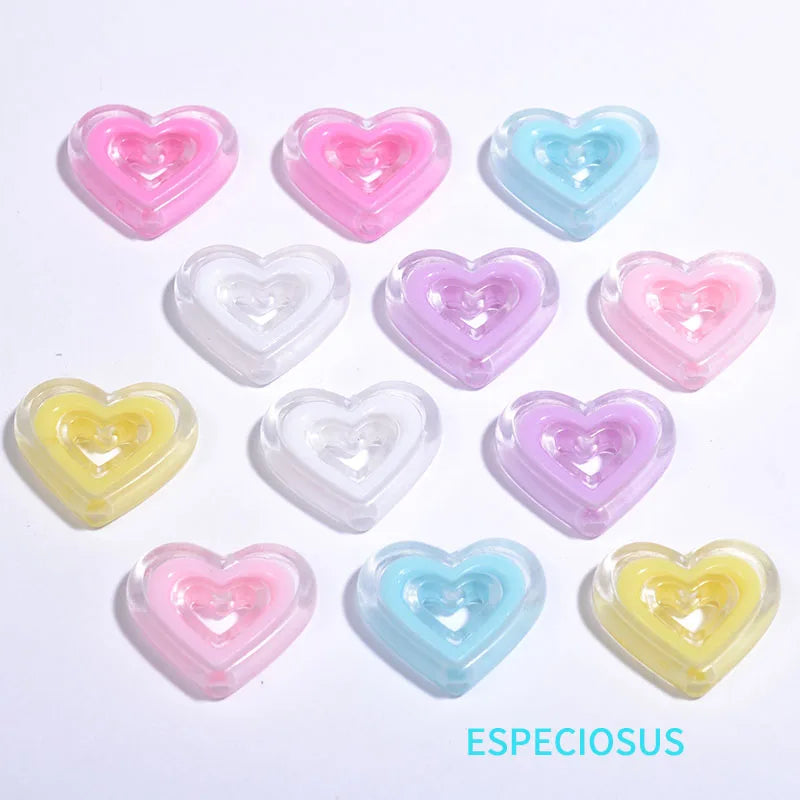 A collection of multi-color heart-shaped acrylic charms in pink, purple, and blue.