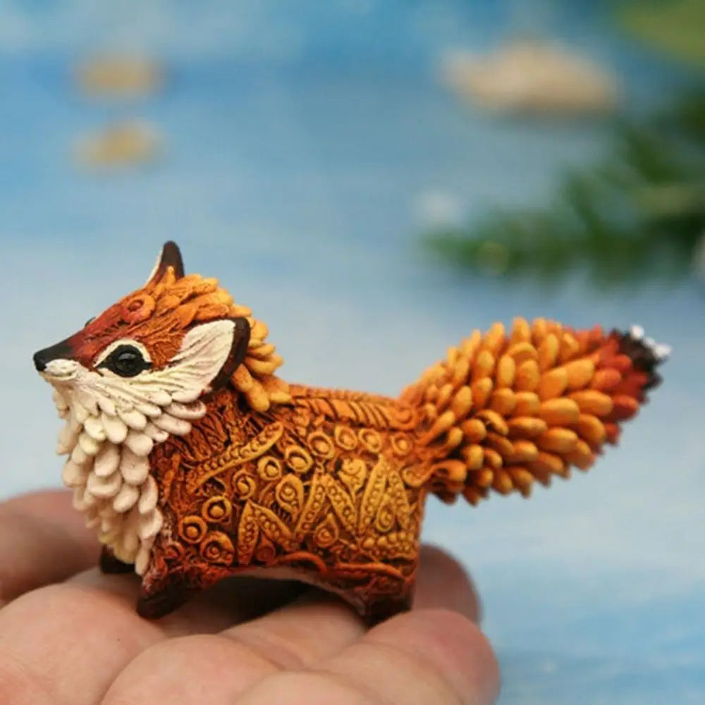 Hand-painted resin fox totem statue with detailed orange and white fur resting on a hand.