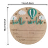 A natural wood birth announcement plaque featuring a teal hot air balloon cutout and the text hello world