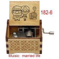 A wooden music box with a lid featuring two figures and an illustration of a house, designed for married life.