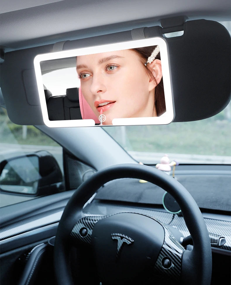 A car sun visor vanity mirror with an LED light showing a woman's face.