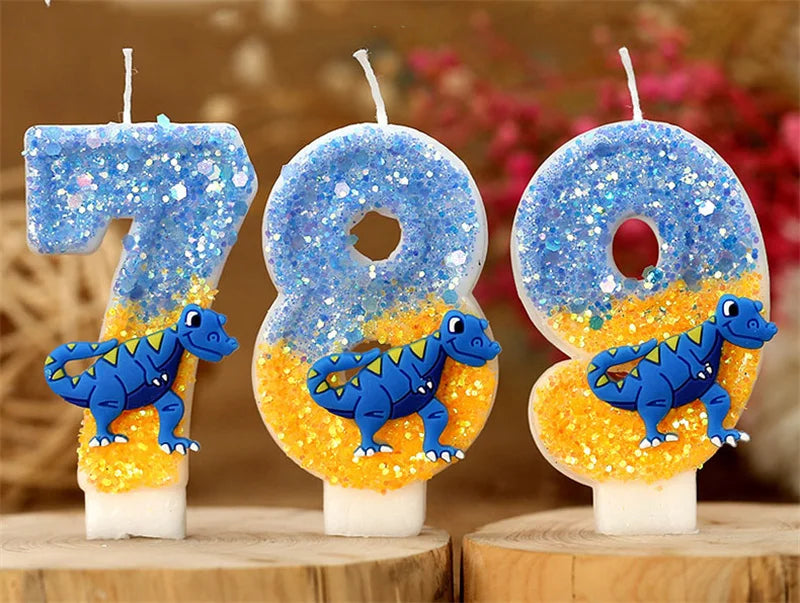 Three birthday candles shaped like the number 789 made of blue and orange glitter on white wax sticks.