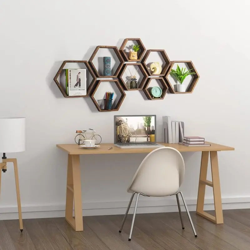 A set of four wooden hexagon floating shelves mounted on a white wall above a light wood desk.