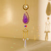 A hanging crystal decor featuring a purple agate stone, gold accents, and clear quartz drops.