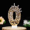 Gold glitter number cake topper featuring a rhinestone crown and bow on a white stick.