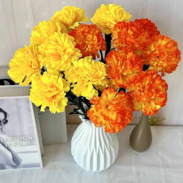 A bouquet of silk artificial chrysanthemum flowers in vibrant yellow and orange hues displayed in a white vase.