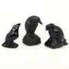 Hand-carved black obsidian raven figurine with a curved posture