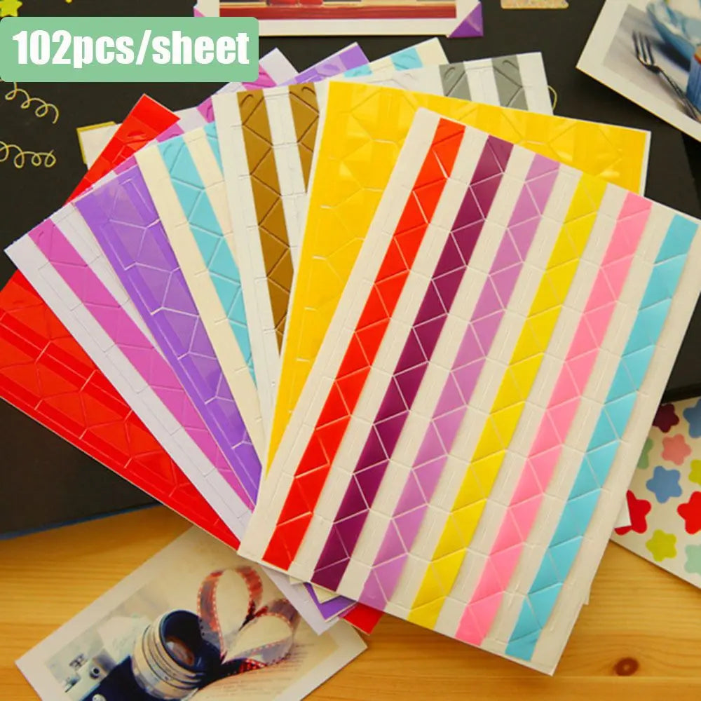 A colorful stack of 102 photo corner protectors in various stripes and solid colors for scrapbooking projects.