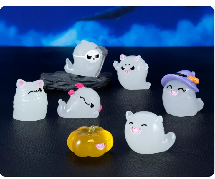A set of seven white luminous ghost resin ornaments, including a purple hat ornament and a yellow pumpkin, displayed on a dar