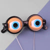 A pair of funny crazy eye costume glasses with large, round, blue and white lenses and black frames.