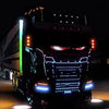 A black truck is illuminated with bright blue and red LED lights on its grille and headlights.