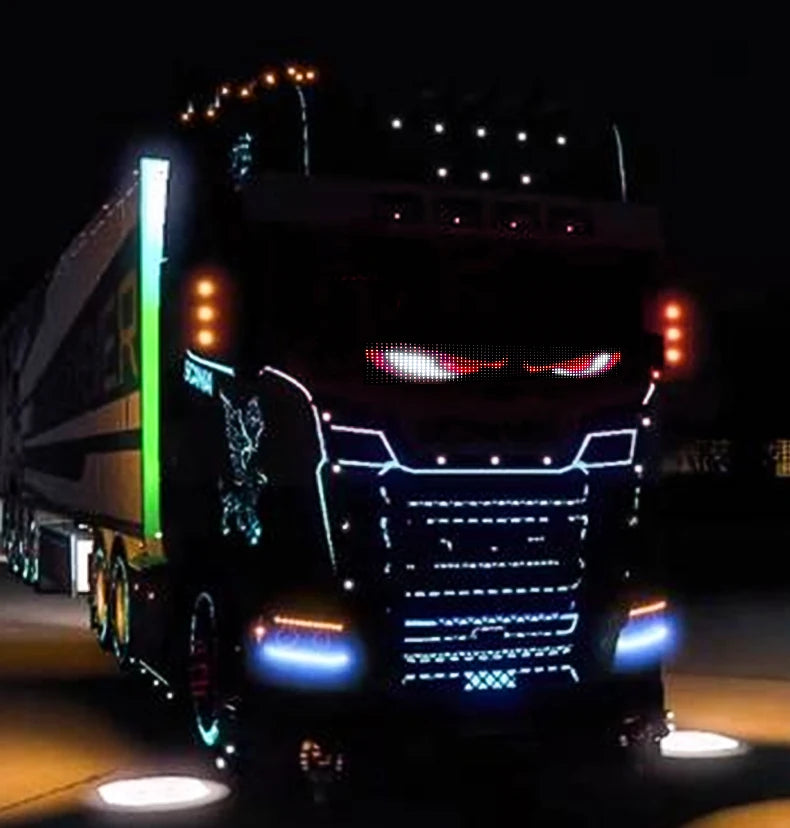 A black truck is illuminated with bright blue and red LED lights on its grille and headlights.
